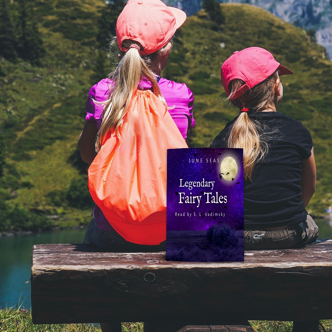 two children with long hair in pony tails and pink baseball caps sit on a wooden bench, with an orange backpack, looking out at a green hill, a river and blue skies. Behind them is a book, Legendary Fairy Tales, dark blue purple background, full moon, flying geese and stars in the sky